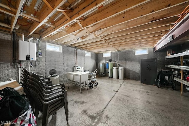 basement featuring brick wall and tankless water heater