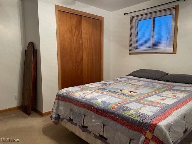 bedroom featuring light colored carpet and a closet