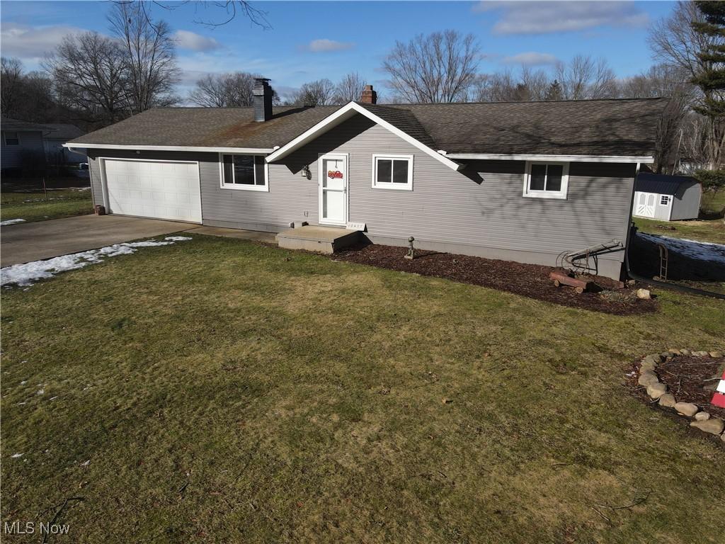 10457 Persimmon St NW, Canal Fulton, OH 44614 - view of front facade featuring a garage and a front yard
