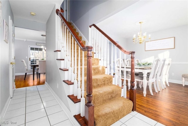 stairway with a chandelier and tile patterned flooring