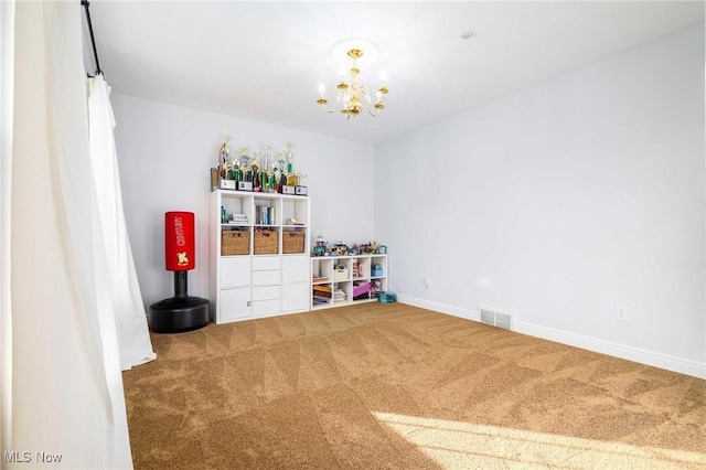 recreation room featuring carpet and an inviting chandelier