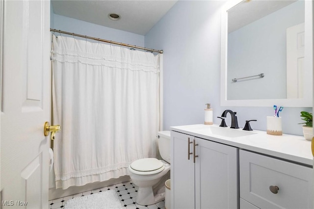 bathroom featuring vanity, toilet, and walk in shower