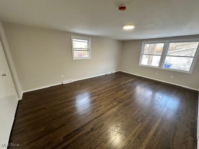 spare room featuring dark wood-type flooring