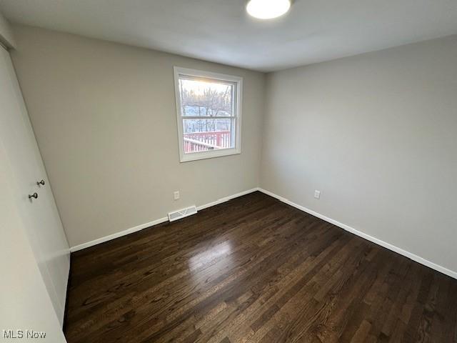 empty room with dark hardwood / wood-style floors