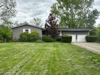 view of property exterior with a yard, driveway, and an attached garage