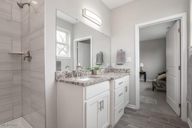 bathroom with vanity and a tile shower