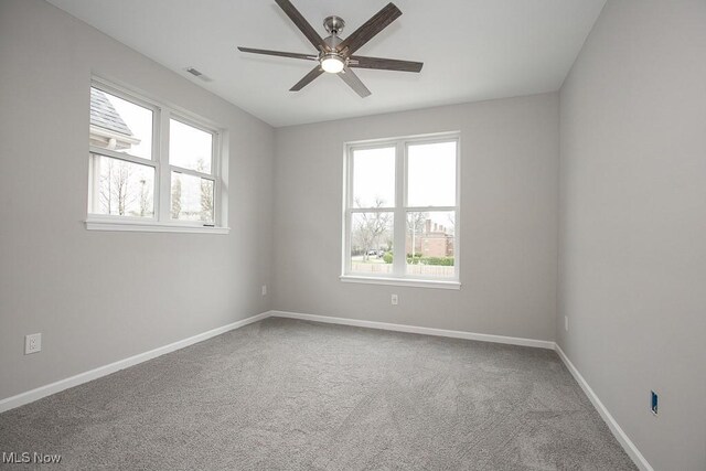 unfurnished room with carpet floors, a healthy amount of sunlight, and ceiling fan