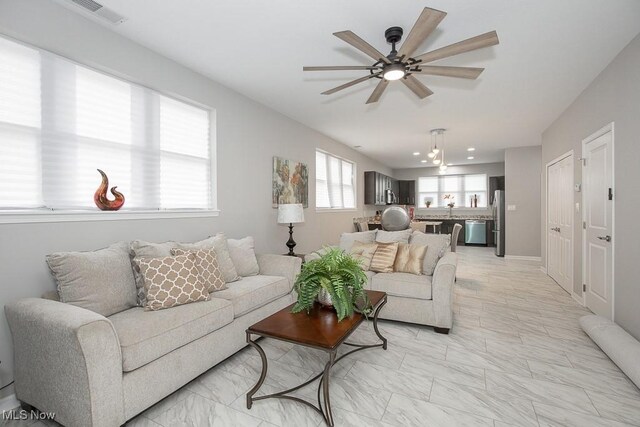 living room with ceiling fan and sink