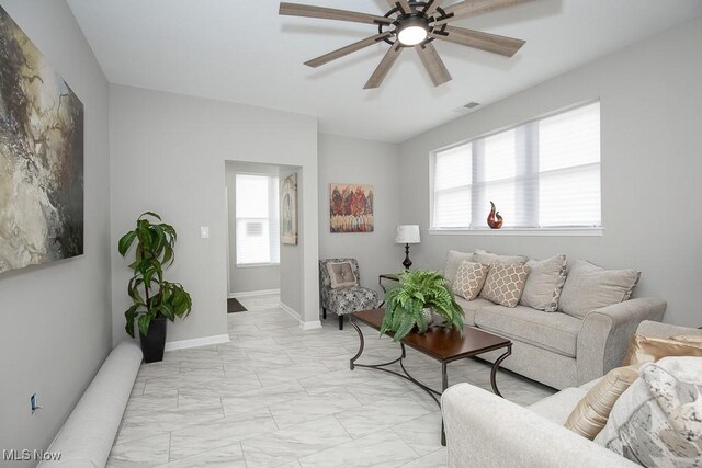 living room with ceiling fan and a healthy amount of sunlight