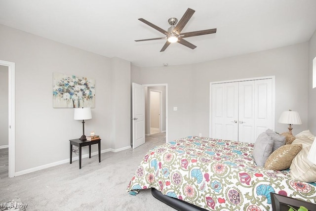 bedroom featuring ceiling fan, light colored carpet, and a closet