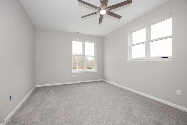 carpeted spare room with ceiling fan