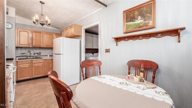 dining room featuring an inviting chandelier, lofted ceiling, sink, and washer and dryer