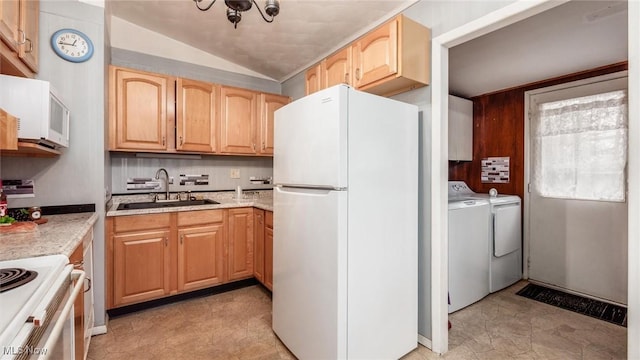 kitchen featuring sink, light stone counters, light brown cabinets, white appliances, and washing machine and dryer