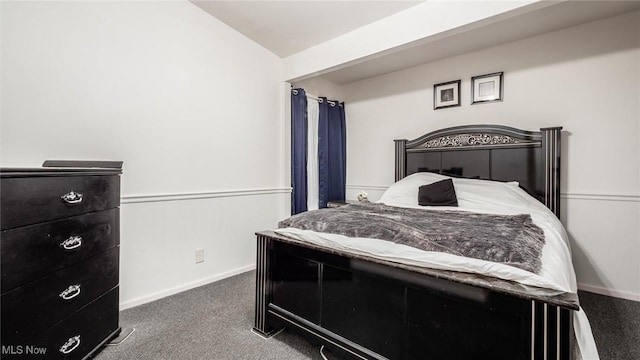 bedroom featuring lofted ceiling and dark colored carpet