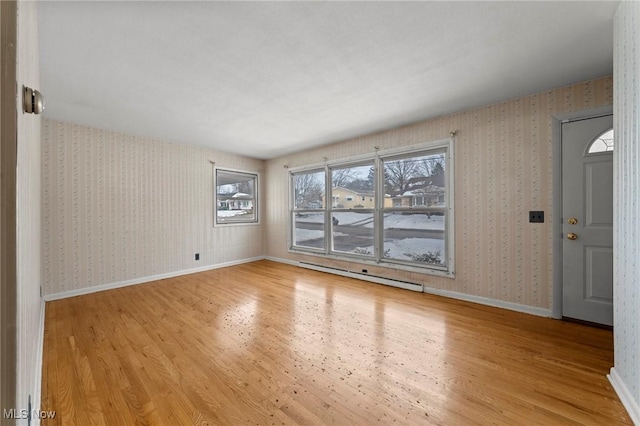 unfurnished room featuring light hardwood / wood-style flooring and a baseboard heating unit