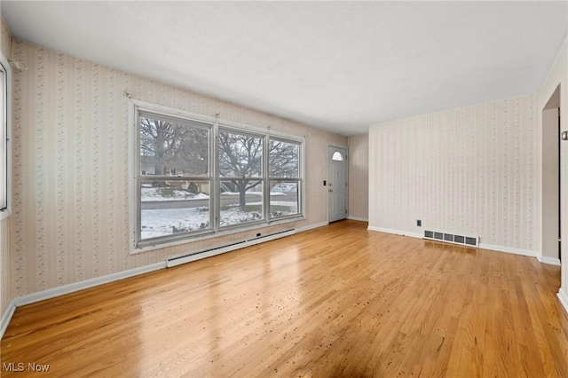 unfurnished room with light hardwood / wood-style flooring and a baseboard radiator