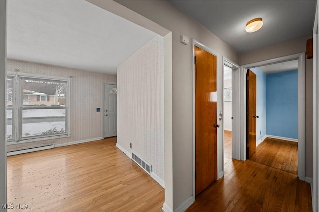 hall featuring hardwood / wood-style flooring and baseboard heating