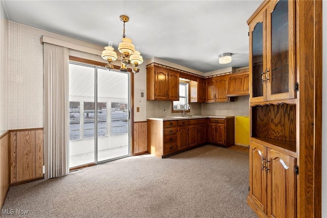 kitchen featuring pendant lighting, sink, an inviting chandelier, and light carpet