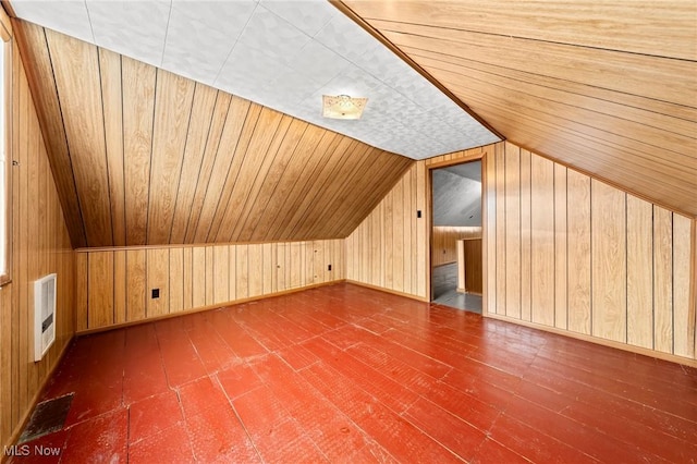 additional living space with heating unit, wooden walls, lofted ceiling, wood ceiling, and dark wood-type flooring