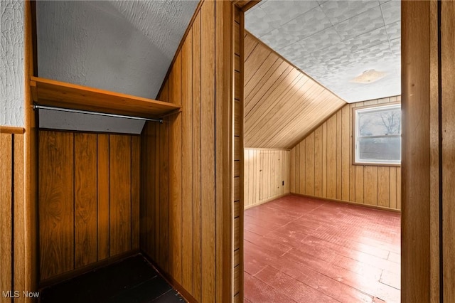 bonus room featuring lofted ceiling, wood-type flooring, and wood walls