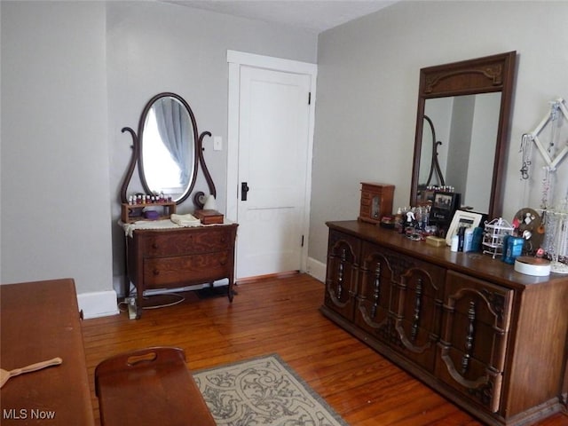 living area featuring baseboards and wood finished floors