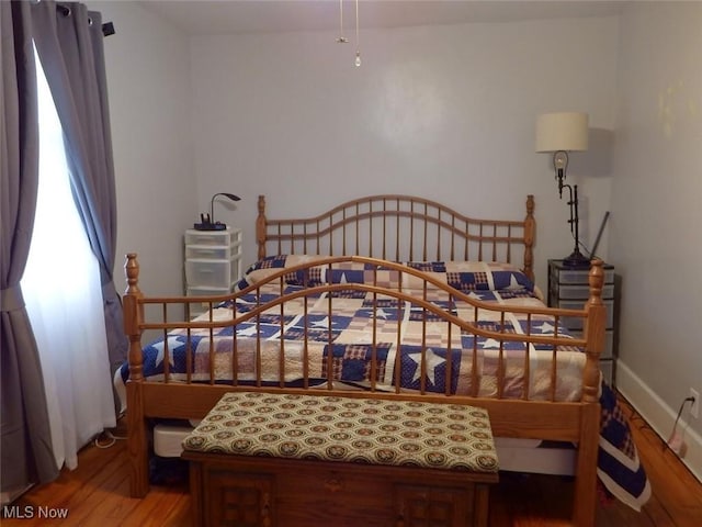 bedroom featuring hardwood / wood-style flooring and stainless steel fridge