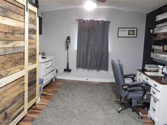 office area with dark wood-type flooring and a barn door