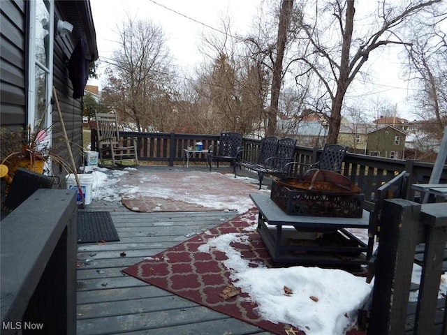 snow covered deck with a fire pit