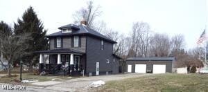 view of front of property with an outbuilding, a garage, and a porch