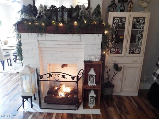 details featuring a brick fireplace and wood-type flooring