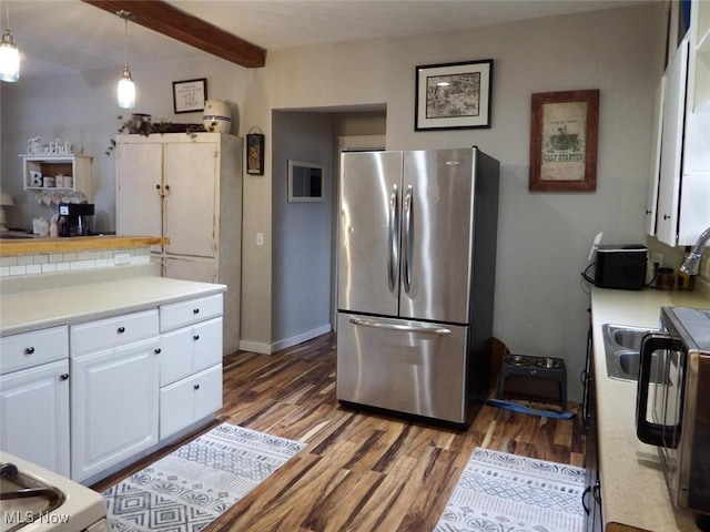 kitchen featuring white cabinets, stainless steel fridge, dark hardwood / wood-style flooring, hanging light fixtures, and beam ceiling