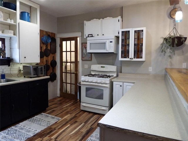 kitchen featuring sink, white cabinetry, tasteful backsplash, dark hardwood / wood-style floors, and white appliances