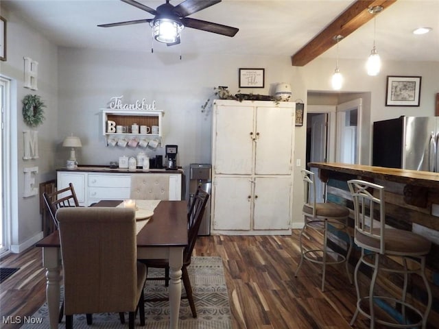 dining space with dark wood-style flooring, baseboards, ceiling fan, and beam ceiling