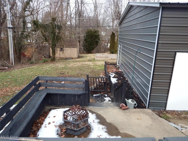 deck featuring a shed, a fire pit, and a yard