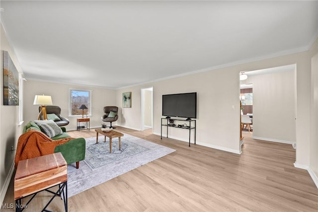 living room featuring crown molding and light hardwood / wood-style flooring