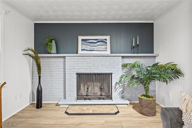 room details with a brick fireplace, wood-type flooring, and ornamental molding