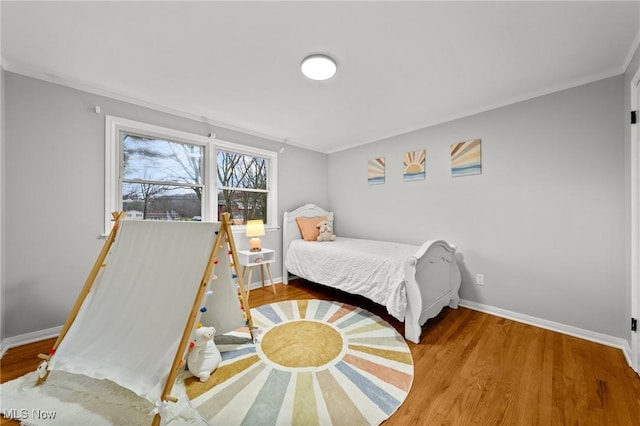 bedroom with crown molding and hardwood / wood-style floors