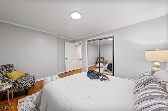 bedroom featuring dark hardwood / wood-style flooring, crown molding, and a closet