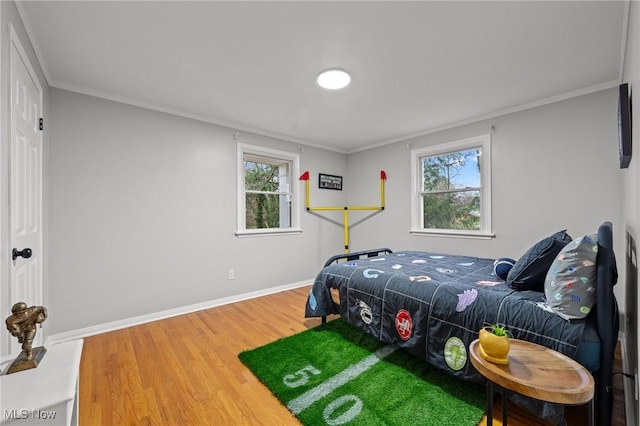 bedroom featuring multiple windows, crown molding, and hardwood / wood-style floors