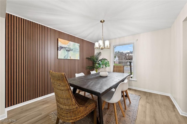 dining space featuring hardwood / wood-style flooring and an inviting chandelier