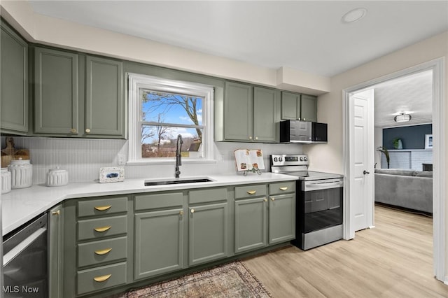 kitchen featuring green cabinetry, sink, light hardwood / wood-style flooring, and electric range