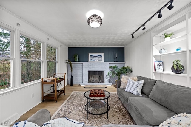 living room with hardwood / wood-style flooring and a brick fireplace