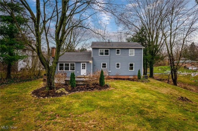 rear view of property featuring a wooden deck and a yard