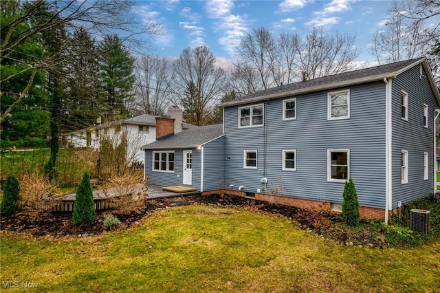 back of house featuring a yard and central AC