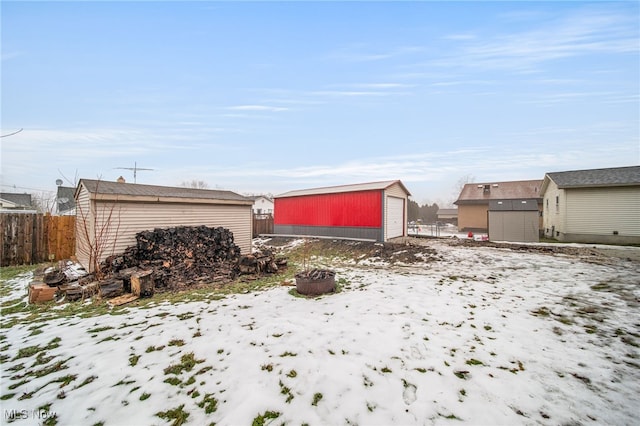 yard covered in snow with a garage and an outbuilding