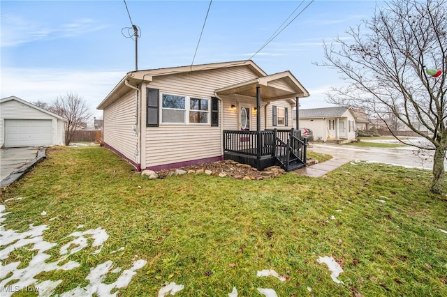 bungalow featuring a garage, an outdoor structure, and a front yard