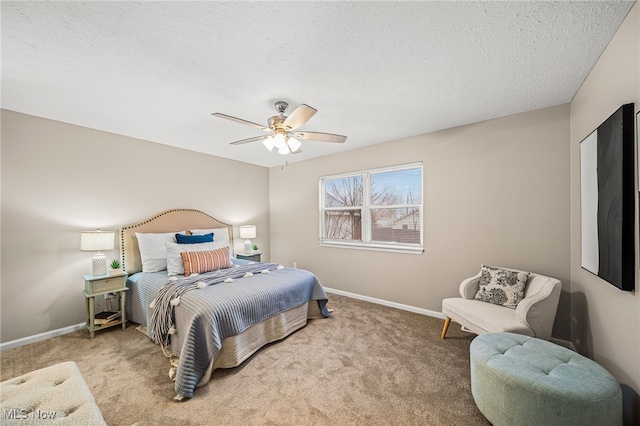 bedroom with ceiling fan, light colored carpet, and a textured ceiling