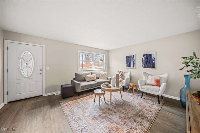 living room with dark hardwood / wood-style floors and a textured ceiling