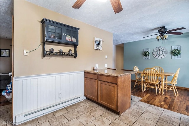 24886 Sherman St, Homeworth, OH 44634 - kitchen featuring ceiling fan, a baseboard heating unit, and a textured ceiling