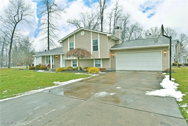 tri-level home featuring a garage and a front lawn